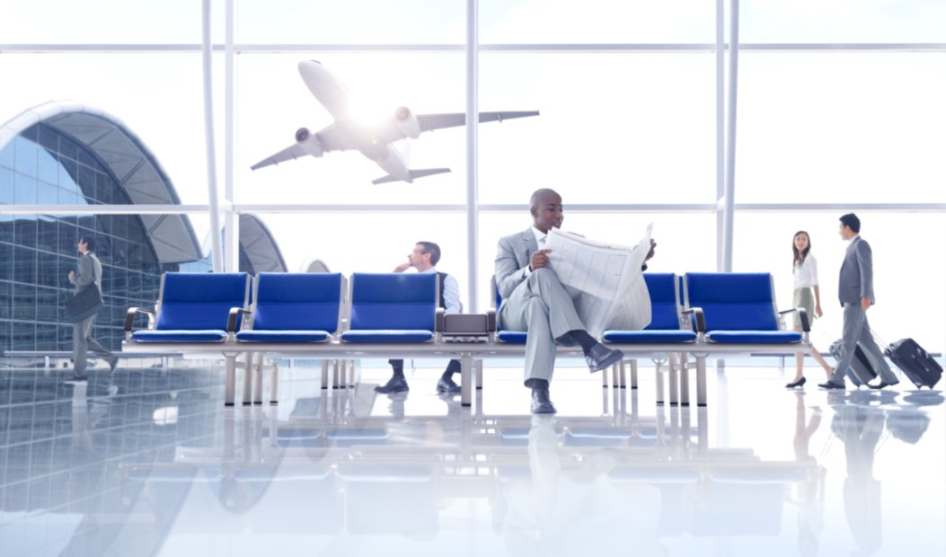 People in the airport with airplane taking off in the background